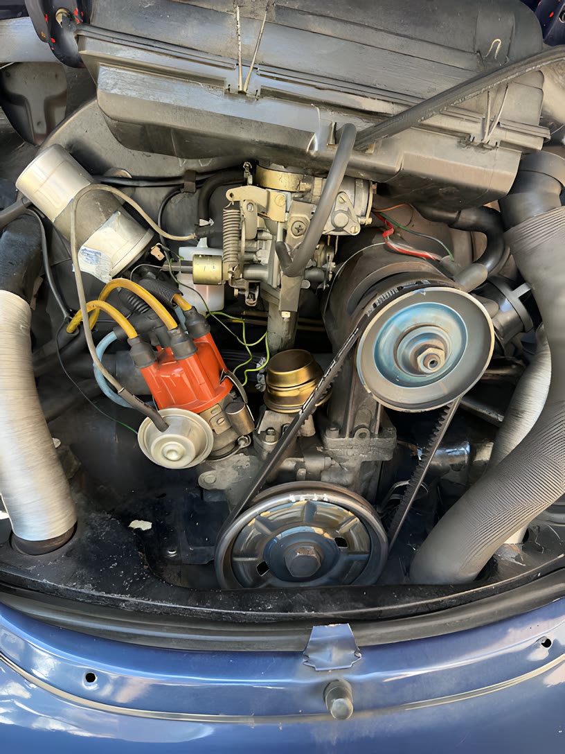 Motorraum eines VW Käfers mit Vergaser und rotem Zündverteiler